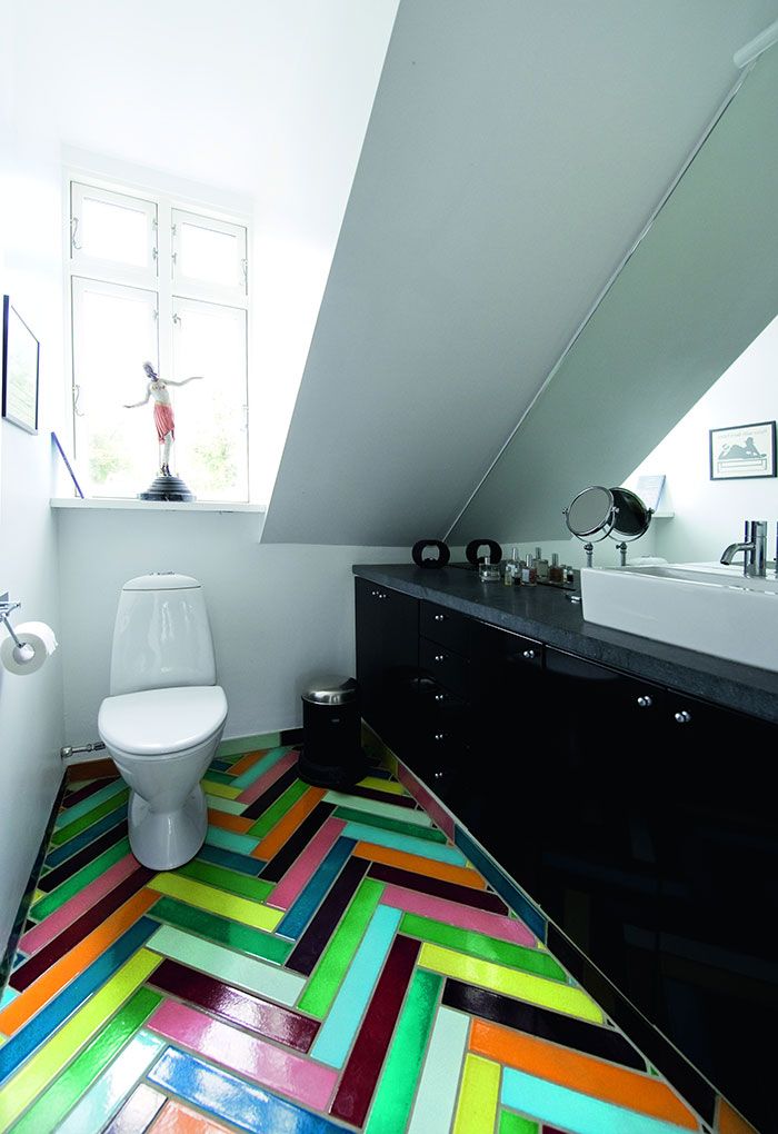На пол в туалете уложена «елочкой» разноцветная яркая плитка