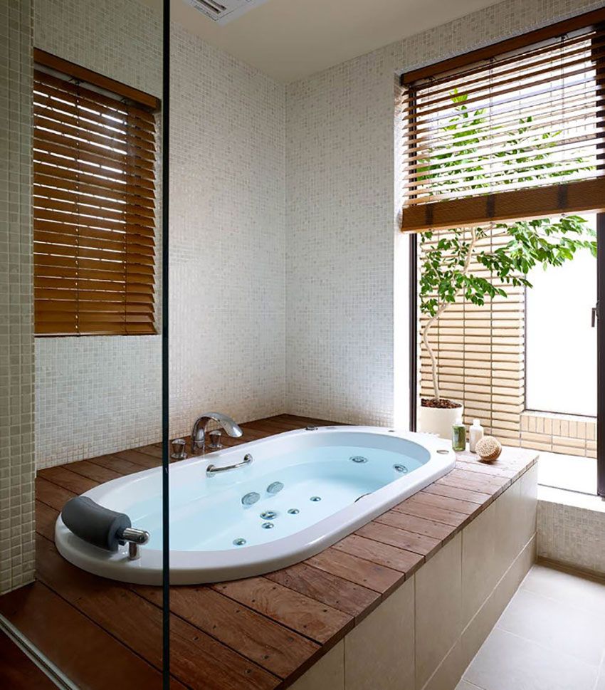 Мозаика в имитации натурального камня полностью покрыла стены компактной ванной