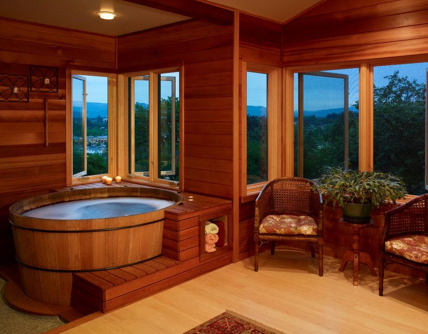 Ванная полностью выполненная из дерева, с круглой купелью и красивым панорамным видом из окон