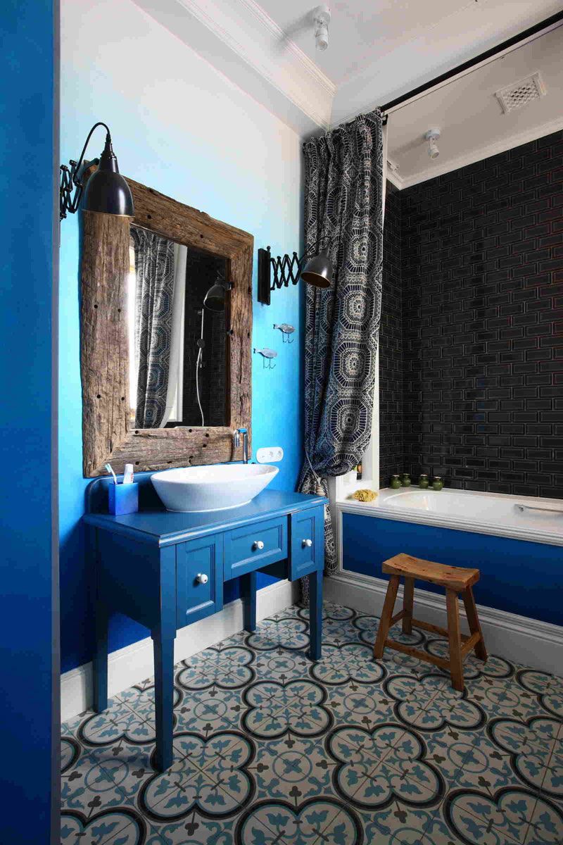 Синяя ванная с орнаментальной плиткой и винтажными элементами мебели