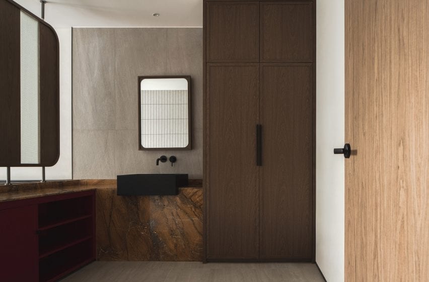 В ванных комнатах дерево хорошо контрастирует со столешницами из каменной породы.