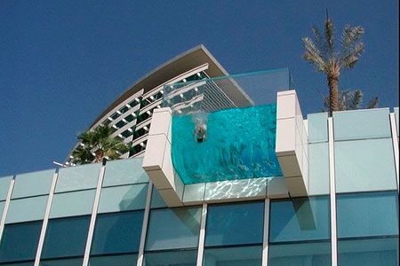 Прозрачная секция органического стекла простирается над краем здания. Виден не только горизонт и окружающие достопримечательности Дубая.