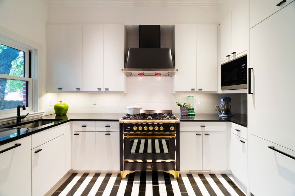 Черно-белый дизайн П-образной кухни в частном доме с удобной мойкой у окна