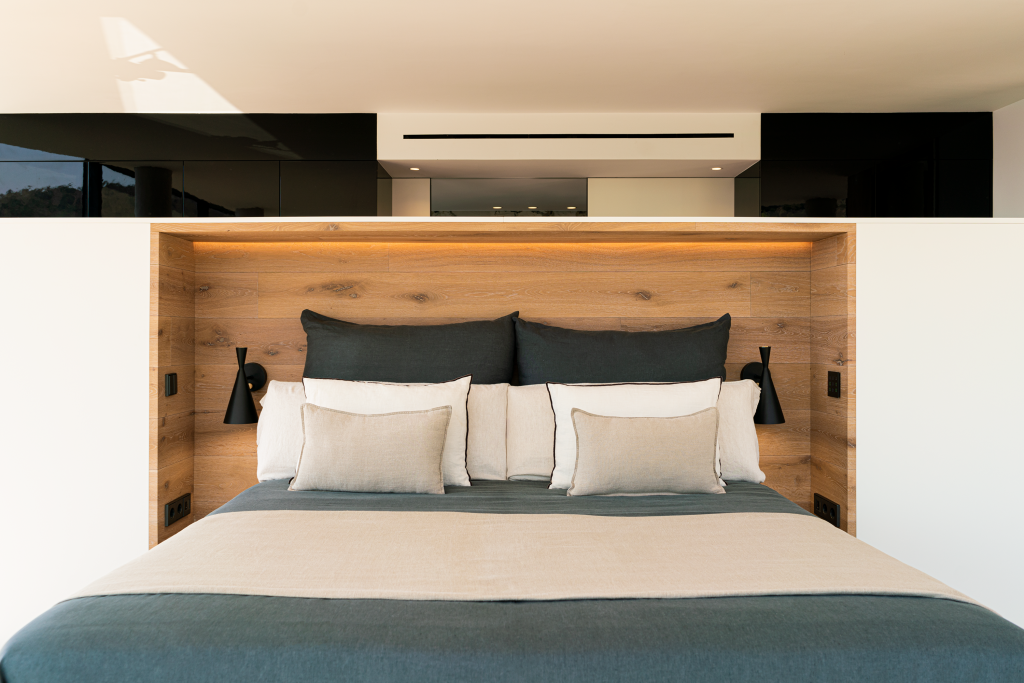 Мебельный модуль служит в качестве изголовья кровати, а с другой стороны выступает в роли гардеробной