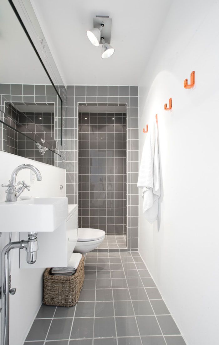 Большое прямоугольное зеркало визуально расширяет помещение ванной комнаты